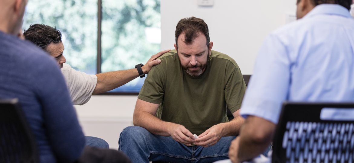 Male therapist encourages distressed male veteran