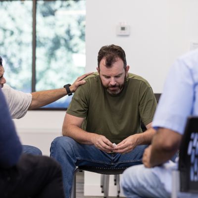 Male therapist encourages distressed male veteran